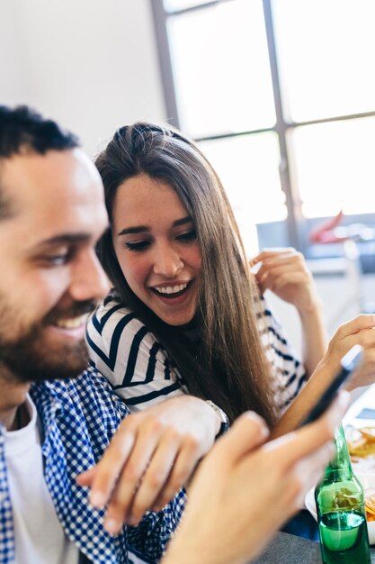 Couple looking at cell phone at dining table