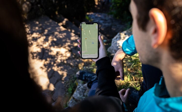 Photo couple looking at digital map and gps in the middle of the forest