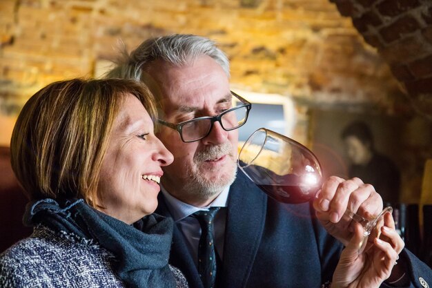 Photo couple looking at red wine in home