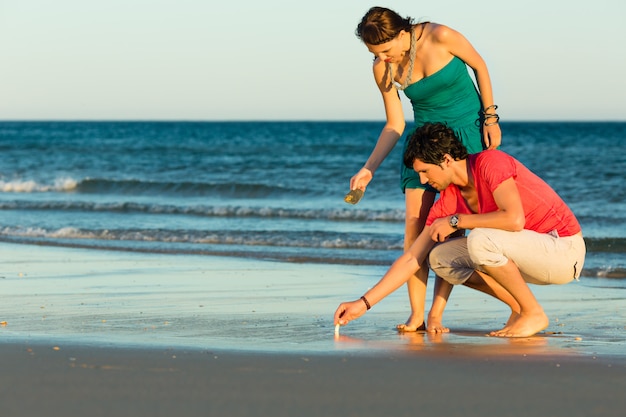 Couple looking for shells at sunset