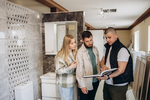 Photo couple looking tiled bathroom they are in a warehouse that sells interior home and bathroom decoration