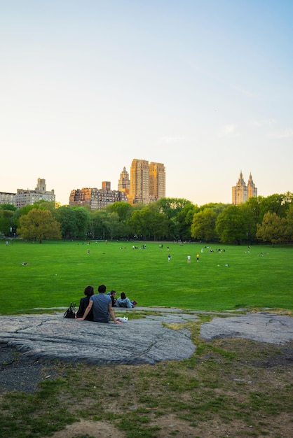 Couple looking at Uptown Manhattan skyline in Central Park West. On Upper West Side in New York, NYC, USA. People nearby