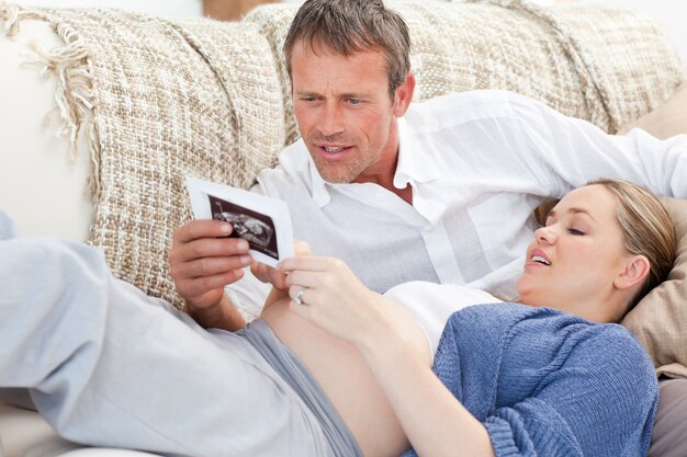 Couple looking at an X-ray on their couch at home