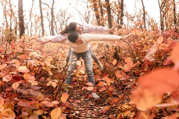 Foto coppia innamorata nelle foglie d'autunno