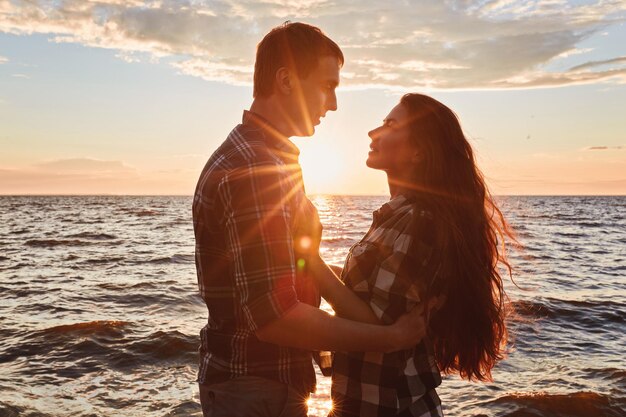 Couple in love back light silhouette at lake sunset