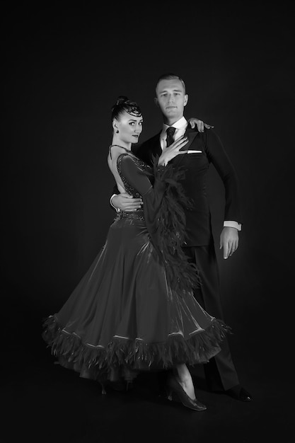 Couple in love ballroon dance couple in red dress and black
tuxedo on black background