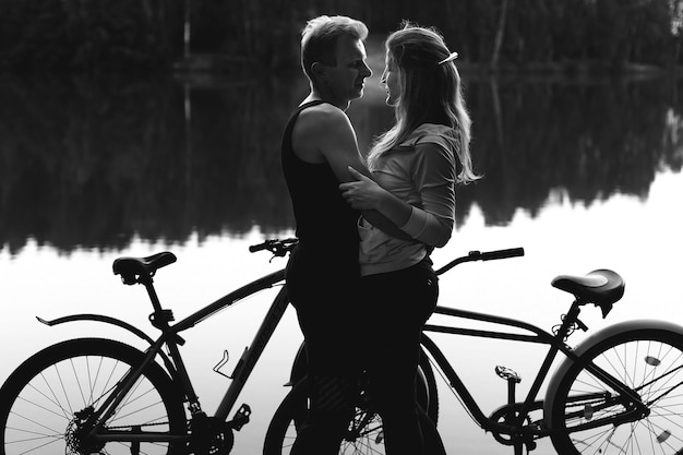 Foto la coppia innamorata sulla spiaggia con le bici, foto in bianco e nero