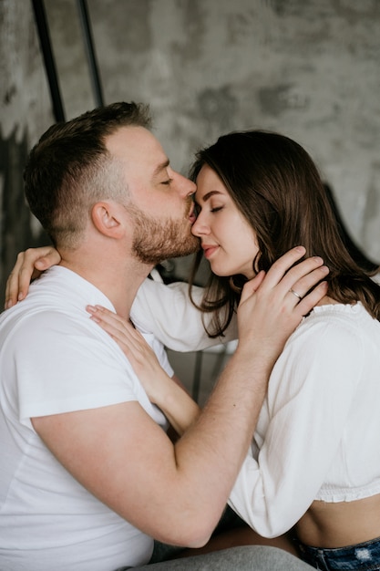 Couple in love in the bedroom. Slender brunette. Stylish interior.