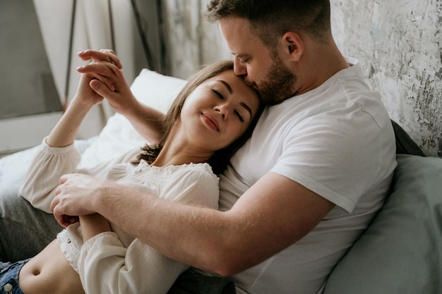 Couple in love in the bedroom. Slender brunette. Stylish interior.