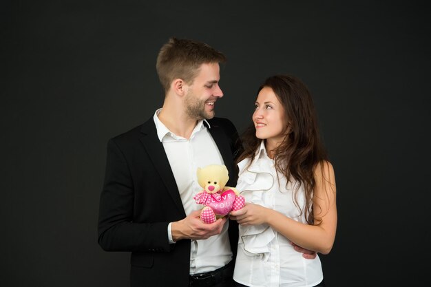 Couple in love celebrate valentines day Surprise Flirting and dating Love and romance Gift with love Couple on romantic date Formal couple with toy Man and woman corporate attire fashion