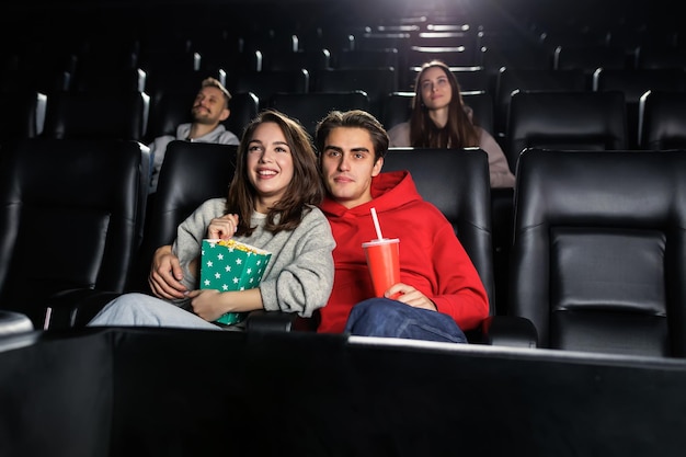 영화관에서 사랑에 빠진 커플 세련된 사람들이 검은색 가죽 시트에 앉아 있다