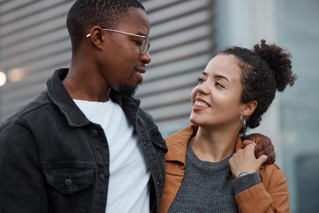 Couple love and diversity with a man and woman outdoor walking together in an urban city during the day Dating relationship and romance with a young male and female outside in town with a smile