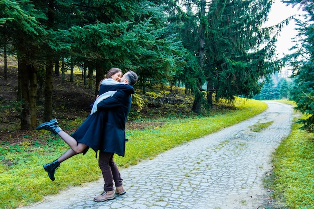 Couple in love dressed in coats in the woods