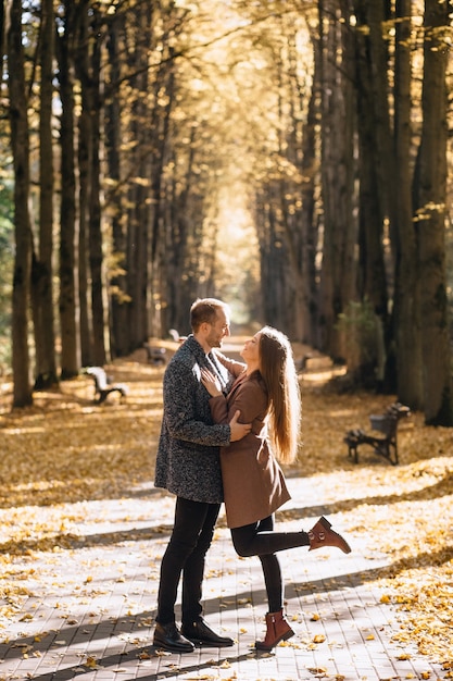 Photo a couple in love embracing in an autumn park at sunset