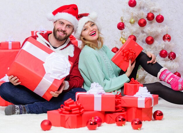 Photo couple in love enjoy christmas holiday celebration. woman and bearded man wear santa claus hat christmas tree background. christmas eve with darling. love is best gift. family married couple at home.