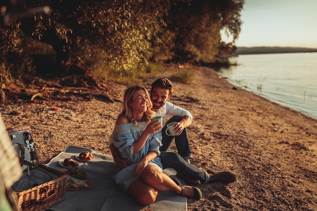 Couple in love enjoying coffee time on the picnic