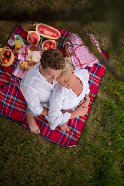 Couple in love enjoying picnic time drink and food in beautiful nature on the river bank top view