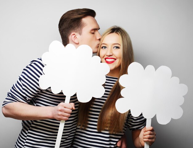 Couple, love and family concept: amorous couple holding blank paper on stick.