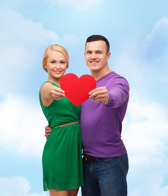 カップル、愛と家族の概念-大きな赤いハートを持って笑顔のカップル