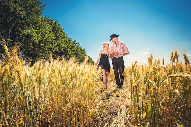 Couple in love going through the field with wheat