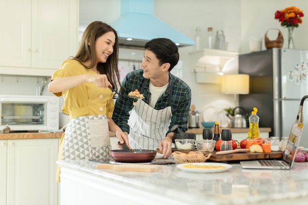 Photo couple in love helping to cook in a romantic atmosphere