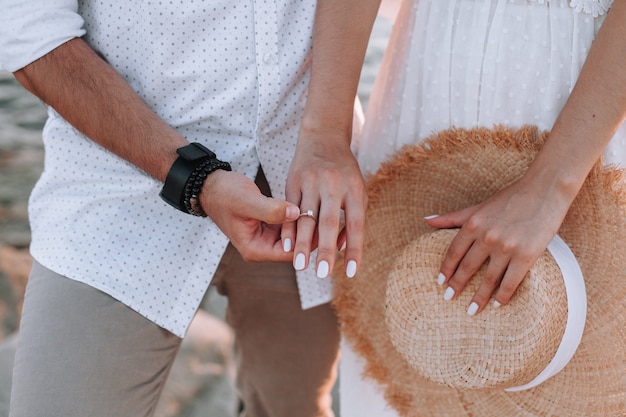 A couple in love holding hands a diamond ring on the girls finger closeup