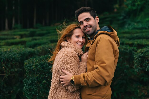 Couple in love hug and look into the camera beautiful smiles c