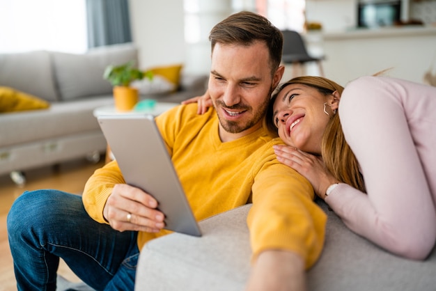 Couple in love hugging and using tablet together.