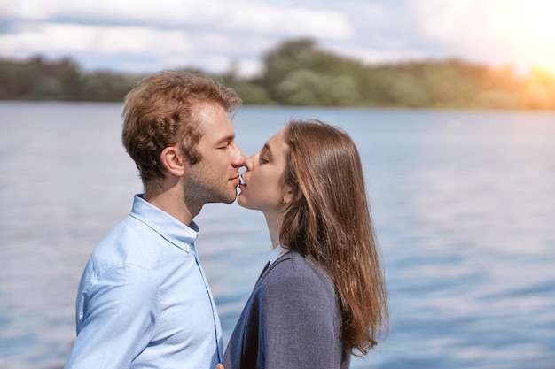 Couple in love kissing standing on the shore of the lake