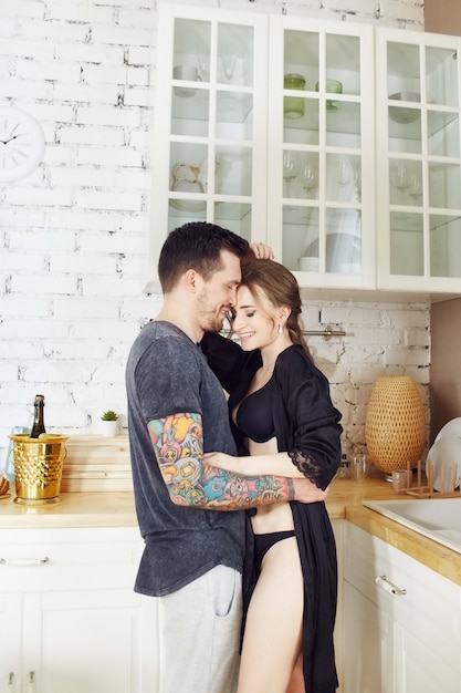 Couple in love in the kitchen in the morning hugs and prepares Breakfast. Happy family life. Joy and smiles on the face of men and women. Love and relationships