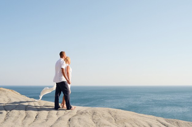 Couple in love looking at the sea holding hands