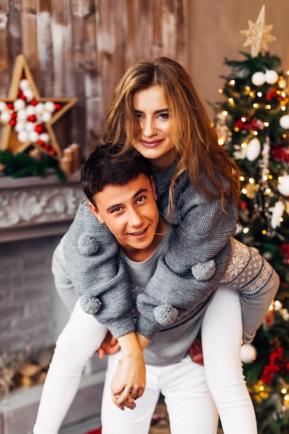 Couple in love near fireplace and Christmas tree guy and girl i