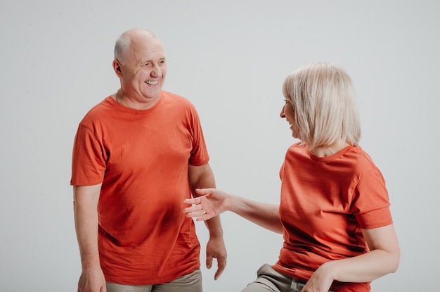 couple in love in orange t-shirts on a white background