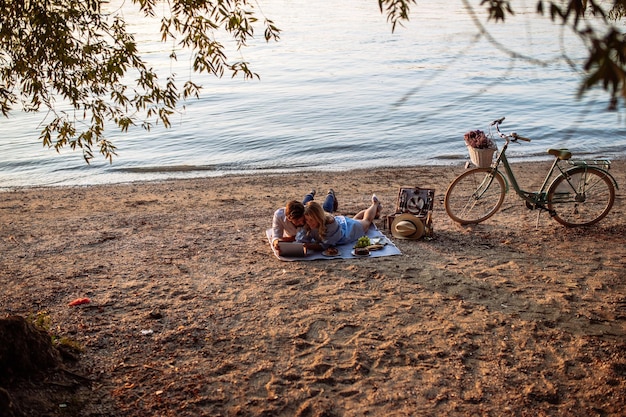 Couple in love on a picnic date using tablet