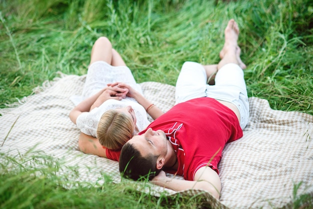 Couple in love at a picnic in a park with green grass