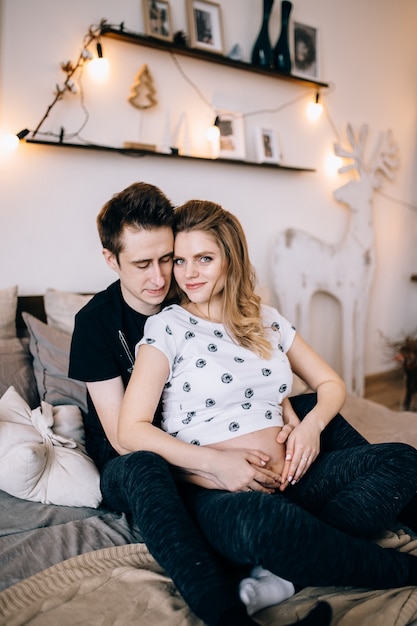 Couple in love pregnant cuddling, waiting for baby
