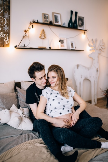 Couple in love pregnant cuddling, waiting for baby
