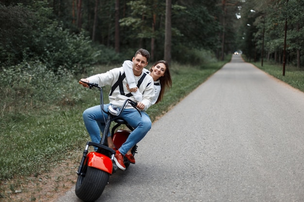 Couple in love riding an electric bike on the road