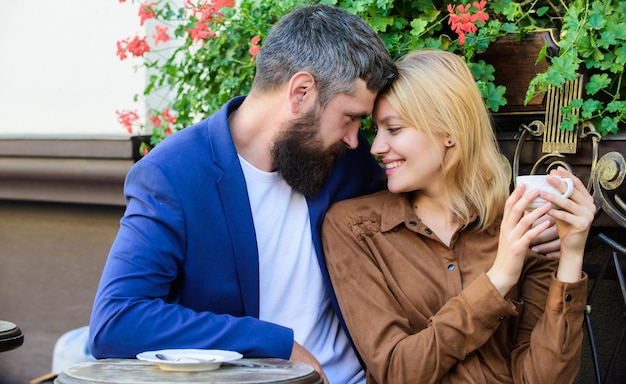 Couple in love sit cafe terrace enjoy coffee Pleasant family weekend Explore cafe and public places Married lovely couple relaxing together Travel and vacation Couple cuddling cafe terrace