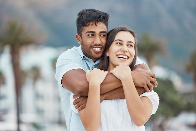 Couple love and smile while hugging and enjoying their vacation holiday and free time together while sharing a laugh joy and commitment Happy man and woman enjoying view and healthy relationship