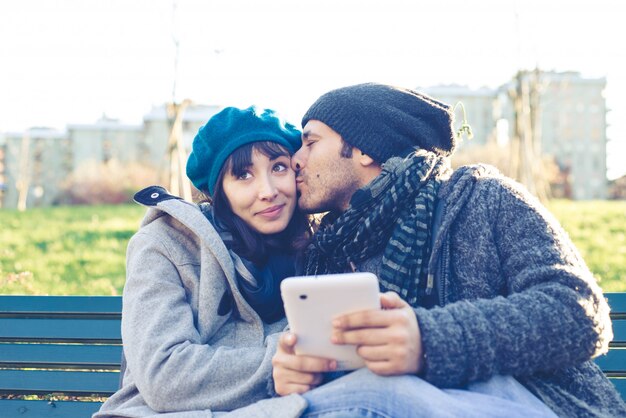 couple in love using tablet at the park