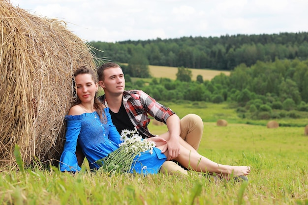 Couple in love in a village field at sunset