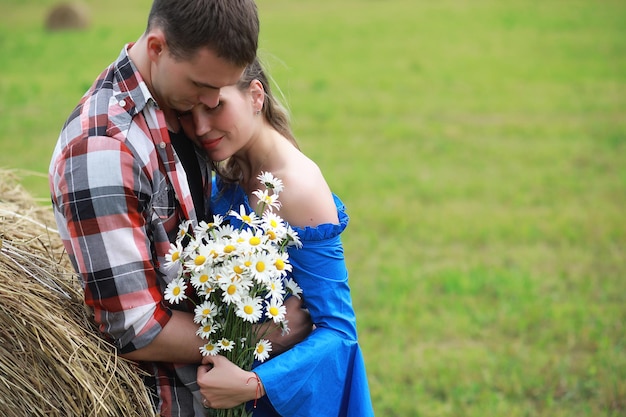 Couple in love in a village field at sunset