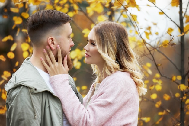 Couple in love walks through autumn forest.