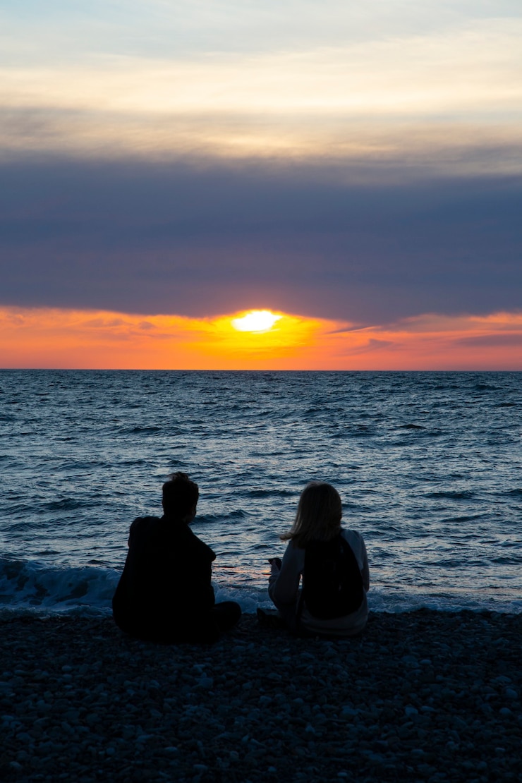 Couple in love watching sunset together on beach