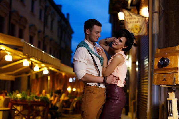 Couple in love while walking in the night city cuddling on the street