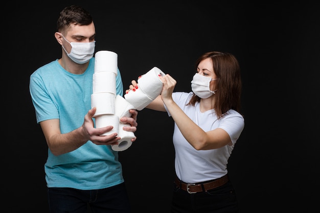 Couple in love in white medical masks are scared by coronavirus and fights for toilet paper