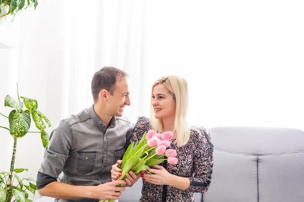 Couple in love with a bouquet of tulips are close to each other