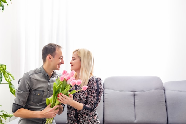 влюбленная пара с букетом тюльпанов рядом друг с другом