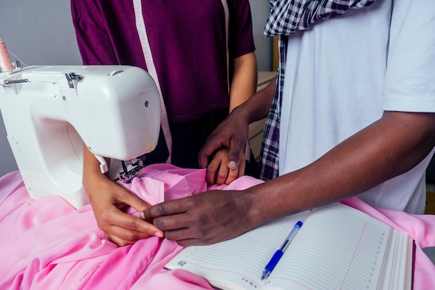 Couple in love working together at home , workshop. african american woman and her boyfriend sewing at living room.